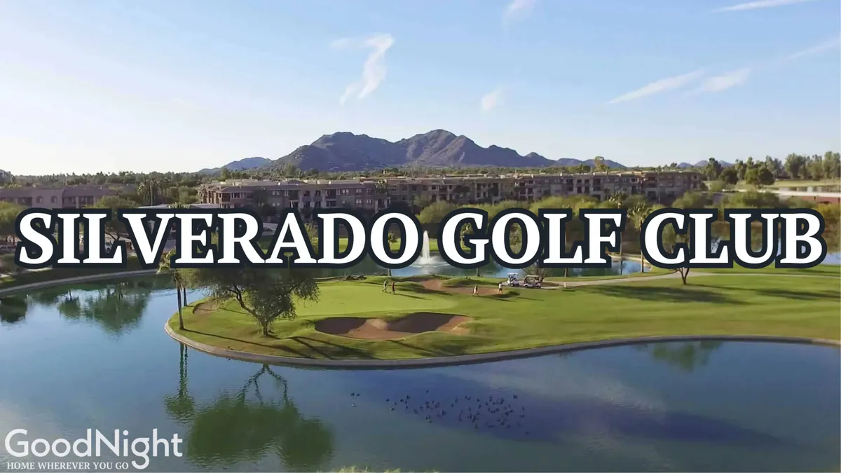 An exterior shot of a golf course with a sparkling lake, mountain backdrop, and a clubhouse nestled among lush greenery. The peaceful atmosphere and ample open space suggest opportunities for nature walks and relaxing outings with pets.